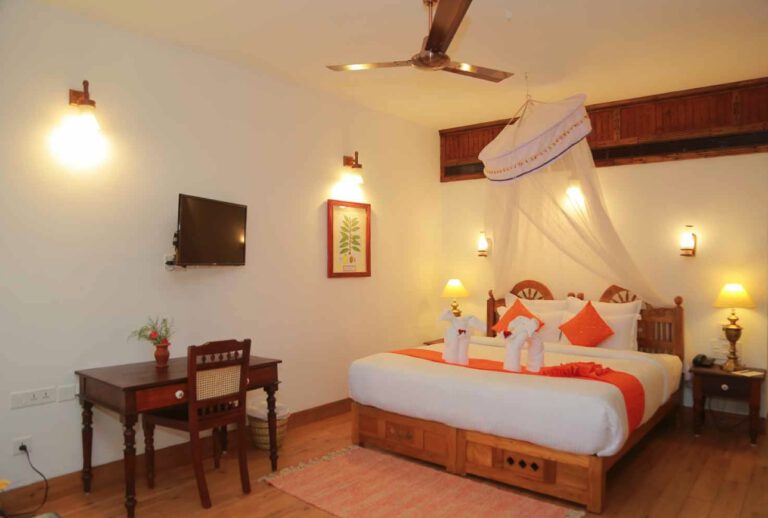 Located on the hillside of the resort, the Deluxe Room offers pleasant views of the surrounding greenery and a comfortable atmosphere for your stay in Kerala. The room is designed in a traditional Kerala style and features a generously sized bedroom with authentic design elements inspired by local craftsmanship. A private bathroom includes a ceramic-coated steel bathtub, specially designed for traditional herbal baths. Blending regional character with everyday comfort, the Deluxe Room is well suited for travellers Deluxe-room-ayursoma